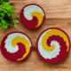 Sabai grass wall decor plate set with red yellow and white spiral woven design