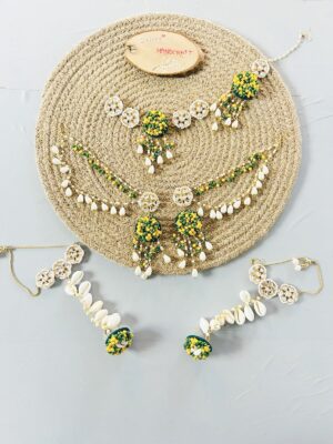 handcrafted floral cowrie shell jewelry set with green stones necklace earrings for haldi mehendi bridal look