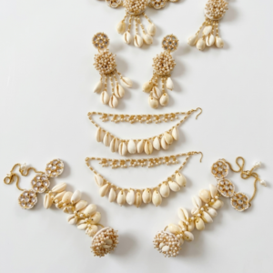 handcrafted beige floral cowrie shell jewelry set with necklace earrings maang tikka for haldi mehendi bridal look