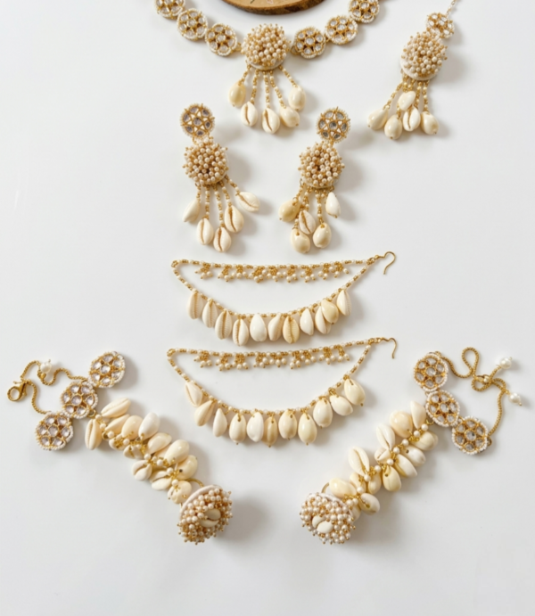 handcrafted beige floral cowrie shell jewelry set with necklace earrings maang tikka for haldi mehendi bridal look